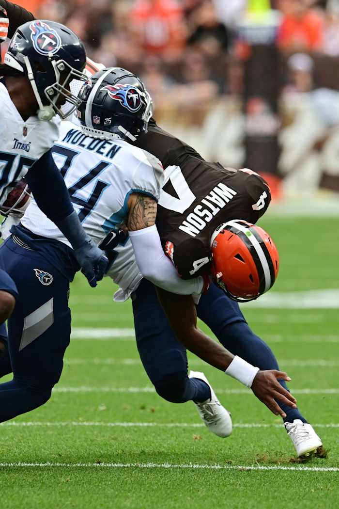 Tennessee Titans cornerback Kristian Fulton (26) tackles Cleveland Browns quarterback Deshaun Watson (4) during the first half at Cleveland Browns Stadium.